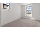 Bright bedroom with carpeted floor, white walls and black framed windows allowing natural light at 20308 W Roma Ave, Buckeye, AZ 85396