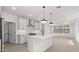 Open concept kitchen with white cabinets, island, and stainless steel appliances at 20308 W Roma Ave, Buckeye, AZ 85396