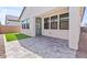 Covered patio features stone flooring, artificial turf, and black framed windows and door at 20308 W Roma Ave, Buckeye, AZ 85396