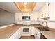 Bright kitchen features white cabinets, a tile floor, and modern appliances, illuminated by stylish overhead lighting at 2040 S Longmore St # 7, Mesa, AZ 85202