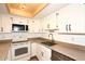 Bright kitchen features white cabinets, a tile floor, and modern appliances, illuminated by stylish overhead lighting at 2040 S Longmore St # 7, Mesa, AZ 85202