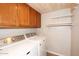 This laundry room features wooden cabinets, floating shelves, and modern washer and dryer units at 2040 S Longmore St # 7, Mesa, AZ 85202