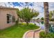 Backyard featuring lush lawn, mature shade trees, brick patio and waterfront access at 20740 N 62Nd Ave, Glendale, AZ 85308