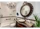 Elegant bathroom featuring a chandelier, tub-shower, decorative mirror, and wooden cabinet sink at 20740 N 62Nd Ave, Glendale, AZ 85308