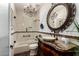 Elegant bathroom featuring a chandelier, tub-shower, decorative mirror, and wooden cabinet sink at 20740 N 62Nd Ave, Glendale, AZ 85308