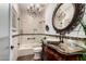 Elegant bathroom featuring a chandelier, tub-shower, decorative mirror, and wooden cabinet sink at 20740 N 62Nd Ave, Glendale, AZ 85308