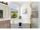 Bright bathroom featuring a soaking tub with garden view, vanity with sink, and glass shower at 20740 N 62Nd Ave, Glendale, AZ 85308