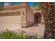 Charming home featuring a stone facade, arched entryway, and lush purple flowering bushes at 20740 N 62Nd Ave, Glendale, AZ 85308