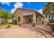 Charming home's rear exterior featuring a brick patio, well-manicured lawn, and mature trees for privacy at 20740 N 62Nd Ave, Glendale, AZ 85308