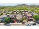 This is an aerial view of a vibrant neighborhood with mature trees and landscaped yards, near a mountain range at 21155 W Green St, Buckeye, AZ 85396