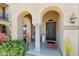Charming front entry with arched columns, cozy seating, and a stylish dark wood door at 21155 W Green St, Buckeye, AZ 85396