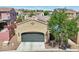 Charming home featuring a gray garage door, desert landscaping, and solar panels nestled in a scenic mountain community at 21155 W Green St, Buckeye, AZ 85396