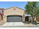 Garage exterior featuring a gray garage door, adjacent to patio area, and desert landscaping at 21155 W Green St, Buckeye, AZ 85396