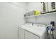 Laundry room featuring a side-by-side washer and dryer, storage baskets, and cleaning supplies at 21155 W Green St, Buckeye, AZ 85396