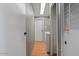 Clean hallway leading to a laundry room, featuring neutral walls and hardwood floors at 2121 N Center St # 166, Mesa, AZ 85201