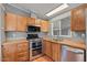 Well-lit kitchen featuring stainless steel appliances and natural wood cabinetry at 2121 N Center St # 166, Mesa, AZ 85201