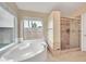 Relaxing primary bathroom with a soaking tub, a glass-enclosed shower, and a large window at 2343 E Kempton Rd, Chandler, AZ 85225