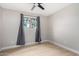 A bedroom featuring a ceiling fan, light wood flooring and a window with grey curtains at 2502 N 22Nd Dr, Phoenix, AZ 85009