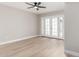 Bright living room with a ceiling fan, light wood floors, and a glass door leading to a patio at 2502 N 22Nd Dr, Phoenix, AZ 85009