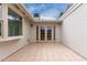 An exterior view of a tiled patio with a large window and glass doors that lead inside at 2502 N 22Nd Dr, Phoenix, AZ 85009
