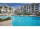 Resort-style pool with multiple lounge areas with umbrellas in front of luxurious condominiums at 2511 W Queen Creek Rd # 244, Chandler, AZ 85248