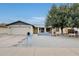 Charming single-story home showcasing desert landscaping, a mature shade tree, and a two-car garage at 2609 N Pleasant Dr, Chandler, AZ 85225