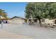 Charming single-story home showcasing desert landscaping, a mature shade tree, and a two-car garage at 2609 N Pleasant Dr, Chandler, AZ 85225