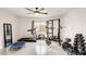 A home gym features a ceiling fan, window, bench with weights, treadmill, and trampoline at 2609 N Pleasant Dr, Chandler, AZ 85225