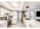 Well-lit kitchen features stainless steel appliances, white cabinets, and a stylish tile backsplash at 2609 N Pleasant Dr, Chandler, AZ 85225