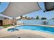 Inviting backyard pool with a tanning ledge, lush landscaping, and shaded seating at 2609 N Pleasant Dr, Chandler, AZ 85225