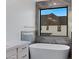 Bright bathroom featuring a modern tub with marble surround and exterior window view at 26631 S 169Th Pl, Queen Creek, AZ 85142