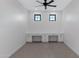 Bright bonus room with built-in desks, neutral carpet, ceiling fan, and natural lighting from two windows at 26631 S 169Th Pl, Queen Creek, AZ 85142