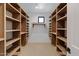 Unfinished walk-in closet with wooden shelving and natural light from window at 26631 S 169Th Pl, Queen Creek, AZ 85142