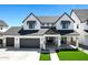 New home with an eye-catching white and black exterior, a dark garage door, and manicured front lawn at 26631 S 169Th Pl, Queen Creek, AZ 85142