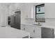 Close up of kitchen featuring stainless steel appliances, white cabinets, and views from the window at 26631 S 169Th Pl, Queen Creek, AZ 85142