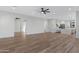 Open living space with wood-look floors, white walls, and transitions to kitchen and bonus room at 26631 S 169Th Pl, Queen Creek, AZ 85142
