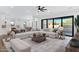 Open-concept living area with plush sofas, stylish decor, and seamless connection to the dining and kitchen at 26631 S 169Th Pl, Queen Creek, AZ 85142