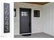 A close up of the front door, siding, and stone exterior of this beautiful new construction home at 26643 S 169Th Pl, Queen Creek, AZ 85142