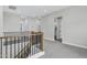 Open hallway featuring carpet flooring, black railing, and multiple doorways at 26643 S 169Th Pl, Queen Creek, AZ 85142