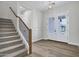 Bright foyer showcases stairs, hardwood floors, wainscoting, and a modern light fixture above the entryway at 26655 S 169Th Pl, Queen Creek, AZ 85142