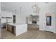 Open-concept kitchen with stainless steel appliances, large island, and seamless flow to the living area with a brick fireplace at 26655 S 169Th Pl, Queen Creek, AZ 85142