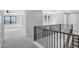 Open loft space with sleek black railing, neutral color palette, and glimpses of a bright bedroom at 26655 S 169Th Pl, Queen Creek, AZ 85142