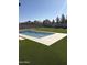 A sparkling rectangular pool surrounded by lush artificial grass provides a serene escape in this backyard at 26655 S 169Th Pl, Queen Creek, AZ 85142