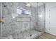 Elegant shower featuring marble-style walls, glass enclosure, and modern fixtures, offering a spa-like experience at 26655 S 169Th Pl, Queen Creek, AZ 85142