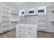 Spacious walk-in closet features custom white shelving, cabinets, and a central dresser at 26655 S 169Th Pl, Queen Creek, AZ 85142