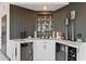 Elegant bar area with wine coolers, display shelving, and modern countertops at 27 W Cochise Dr, Phoenix, AZ 85021