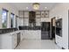 Modern kitchen featuring sleek black and white cabinetry, stainless steel appliances, and a stylish backsplash at 27 W Cochise Dr, Phoenix, AZ 85021