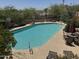 Community pool is surrounded by patio, greenery, and patio furniture at 27 W Cochise Dr, Phoenix, AZ 85021