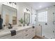 Modern bathroom featuring double sinks, stylish mirrors, and a glass-enclosed shower with block window at 2991 E Folley Pl, Chandler, AZ 85225
