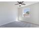 This bright bedroom features neutral carpet, a ceiling fan, and a window overlooking the yard at 2991 E Folley Pl, Chandler, AZ 85225
